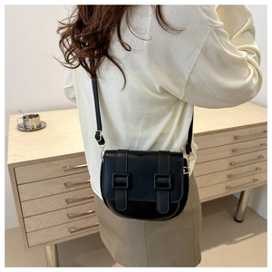 Classic black semi-round saddle bag with decorative straps and golden D-ring hardware