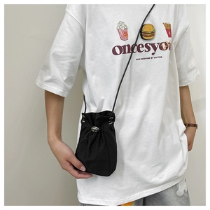 Detailed view of a mini black nylon drawstring bucket bag with silver metal eyelets