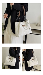 Détail du sac cabas blanc cassé montrant la texture plissée et la bandoulière chaîne