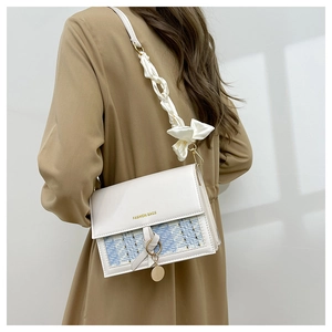 Detail of white chain bag with blue tweed patchwork and silk scarf wrapped handle