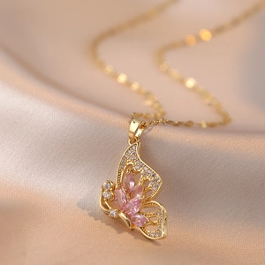 Elegante collana a farfalla dorata con gemma rosa e zirconi brillanti su raso