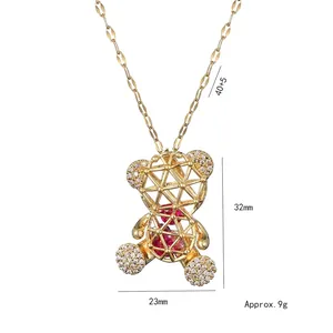 Collier pendentif ours évidé doré avec pierre rouge et zircons sur fond blanc