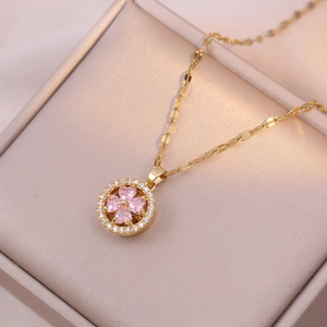 Detail of gold clover necklace with pink heart crystals and micro-set cubic zirconia