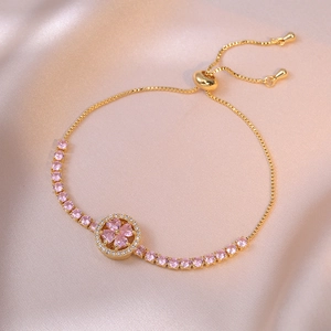 Adjustable gold clover bracelet with pink heart-shaped stones and cubic zirconia