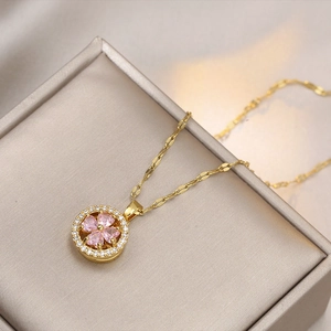 Detail of gold titanium necklace with pink heart gems and white zirconia floral pendant