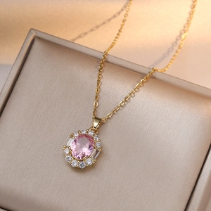 Elegant gold necklace with pink oval zircon pendant on a luxury champagne jewelry box
