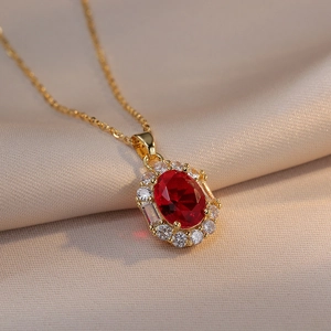 Elegant gold necklace featuring an oval red zircon pendant with a halo of clear crystals