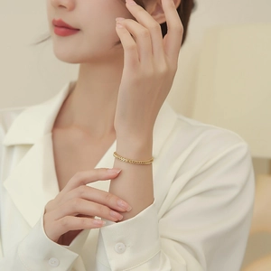 Close-up of golden wheat-link titanium steel bracelet on a woman's wrist
