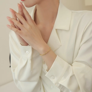 Elegant gold wheat chain titanium steel bracelet for women shown on a model's wrist
