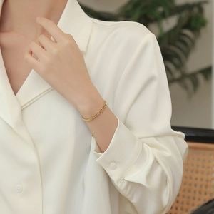 Minimalist gold wheat chain bracelet for women made of elegant stainless steel on wrist