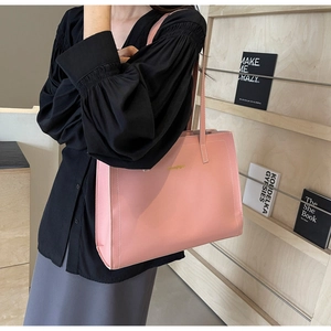 Pale pink leather tote bag featuring golden logo and large capacity for daily commuting