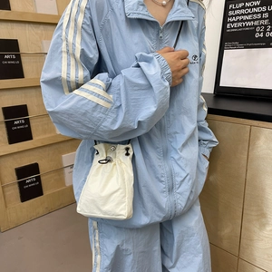 Minimalist light blue shoulder bag for women with drawstring and metal eyelet details