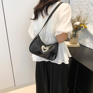 Minimalist black patent leather crescent shoulder bag with large rhinestone heart decoration