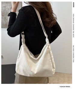 Detail of cream large tote bag with wide shoulder strap and gold adjustment buckle