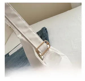 Detail of adjustable metal buckle on high-quality white nylon tote shoulder bag