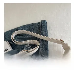 Detail of adjustable strap on beige tote bag with premium golden metal buckle