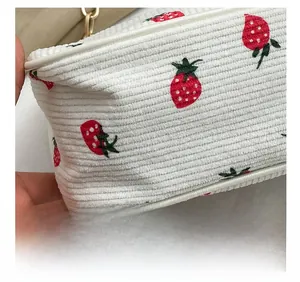 Detail der präzisen Nähte an der weißen Cordtasche mit roten Erdbeer-Stickereien