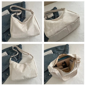 Detailed view of large capacity cream hobo bag with pleated texture and interior storage