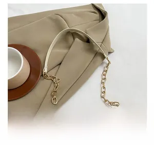 Details der goldenen Metallkette und des Lederriemens der Kordtasche mit Erdbeermuster