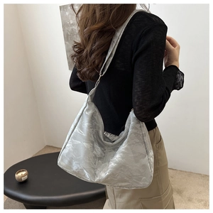 Detail of silver grey hobo bag showing pleated texture fabric and wide strap design