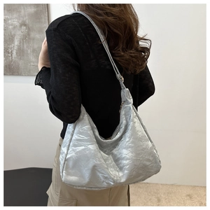 Silver metallic crescent tote bag showing the unique wrinkled texture and slouchy profile