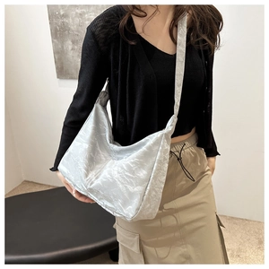 Detail of light grey hobo bag with crinkle texture fabric on a person shoulder