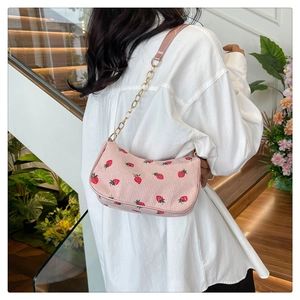 Detailansicht der pinkfarbenen Cord-Schultertasche mit Erdbeerdruck und Goldkette