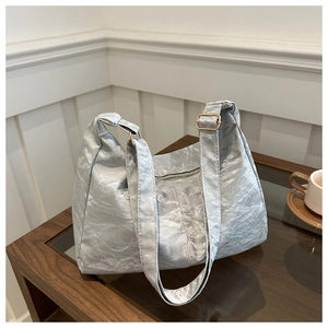 Detailed close-up of silver crinkled texture fabric and zipper on a hobo tote bag