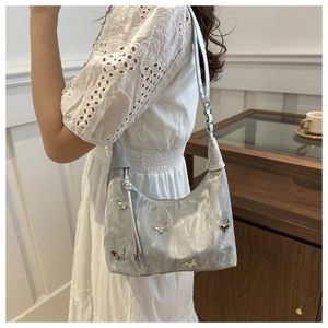 Silver metallic shoulder bag featuring butterfly charms and crinkled leather texture
