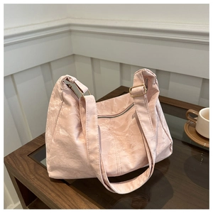 Detail of light pink tote bag featuring marble texture fabric and gold metal hardware
