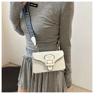 Close-up of a white leather crossbody bag with a blue contrast wide fabric strap