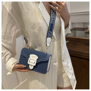 Close-up of small crossbody bag with wide strap and white buckle detail for women