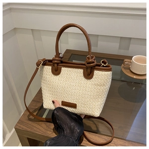 French style straw bucket bag with brown leather trim and adjustable shoulder strap