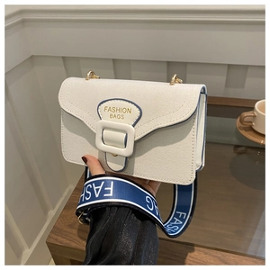 Detail of off-white canvas small square bag with blue trim and wide branded strap