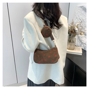 Brown corduroy hobo bag with strawberry print and mini pouch worn by model