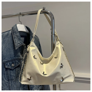 Detail of hobo bag with silver butterfly buckles and glossy cream leather texture