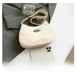 Beige nylon crescent shoulder bag size comparison with a white smartphone