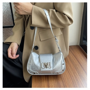 Close-up of silver faux leather shoulder bag featuring crocodile texture and heart buckle