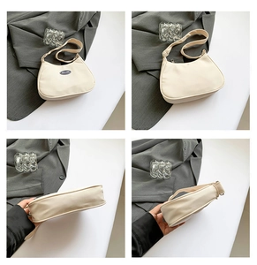 Detail of a beige crescent nylon bag showing textured fabric and adjustable strap