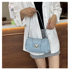 Detail of light blue crocodile texture shoulder bag with silver heart metal buckle