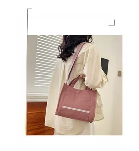 Detail of corduroy tote bag showing fine ribbed texture and adjustable shoulder strap