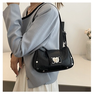 Close-up of black crocodile-textured underarm bag with silver heart-shaped metal buckle