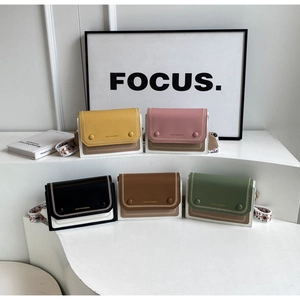 Detail of colorful crossbody bags with contrast stitching and decorative woven strap