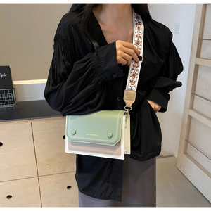 Close-up of contrast color crossbody bag with ethnic style wide strap and decorative buckles