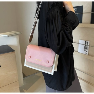 Detail of color-block flap crossbody bag with geometric pattern wide strap on model