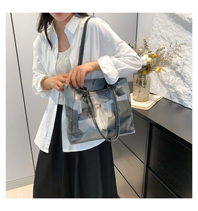 Detail of grey geometric tote bag with fine white stitching and slim shoulder straps