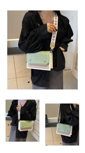 Detail of contrast color square bag with embroidered wide strap and flap stitching