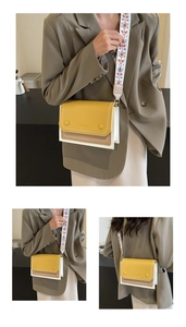 Close-up of tricolor crossbody bag with bohemian wide strap and rivet details