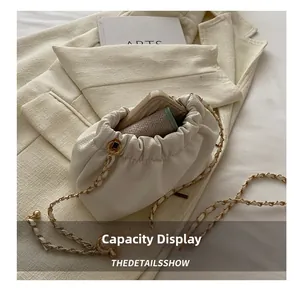 Detail showing capacity of cream drawstring bucket bag with smartphone and wallet