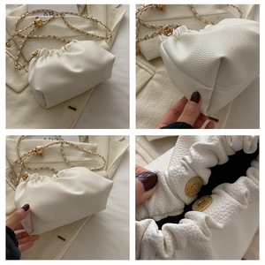 Detail showing white lychee pattern leather texture with golden chain and magnetic buckle